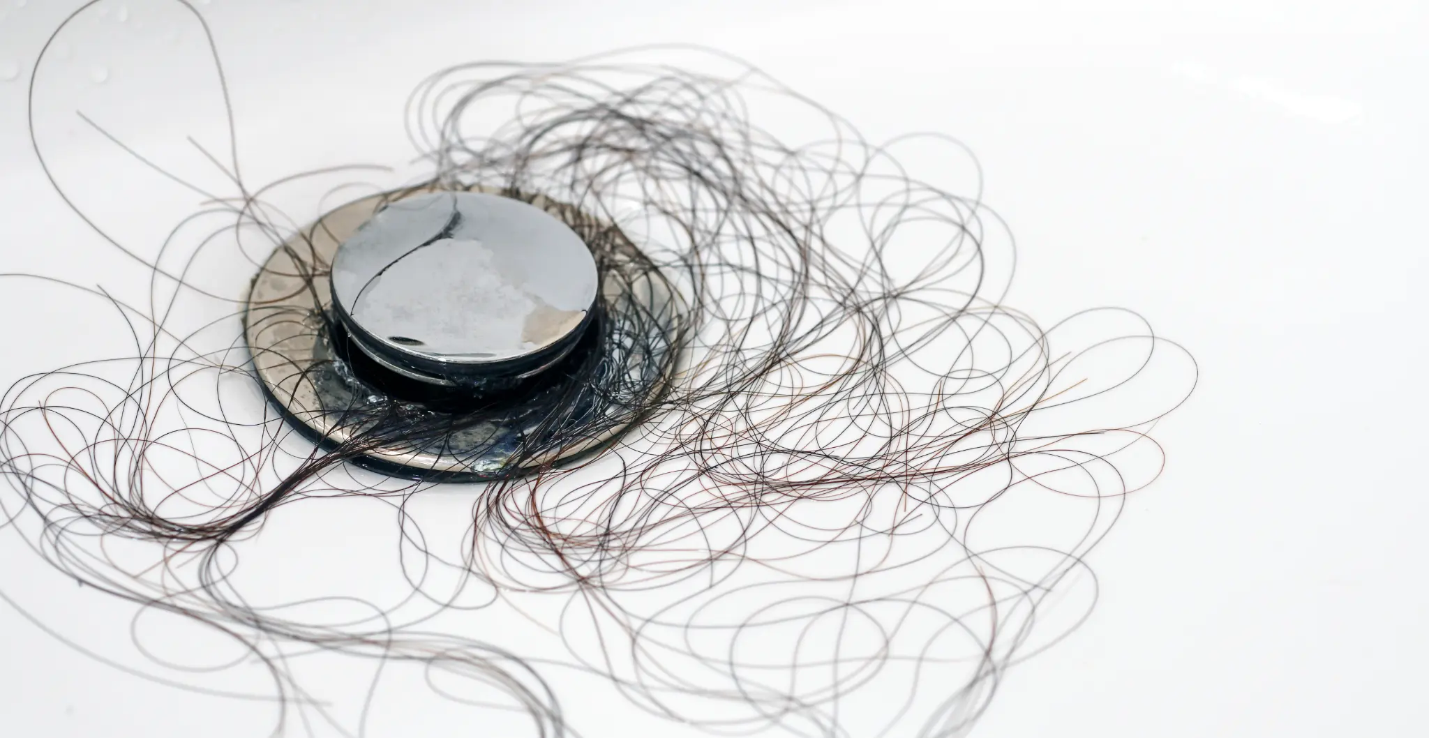 Hair in shower drain — visual metaphor for silent revenue loss