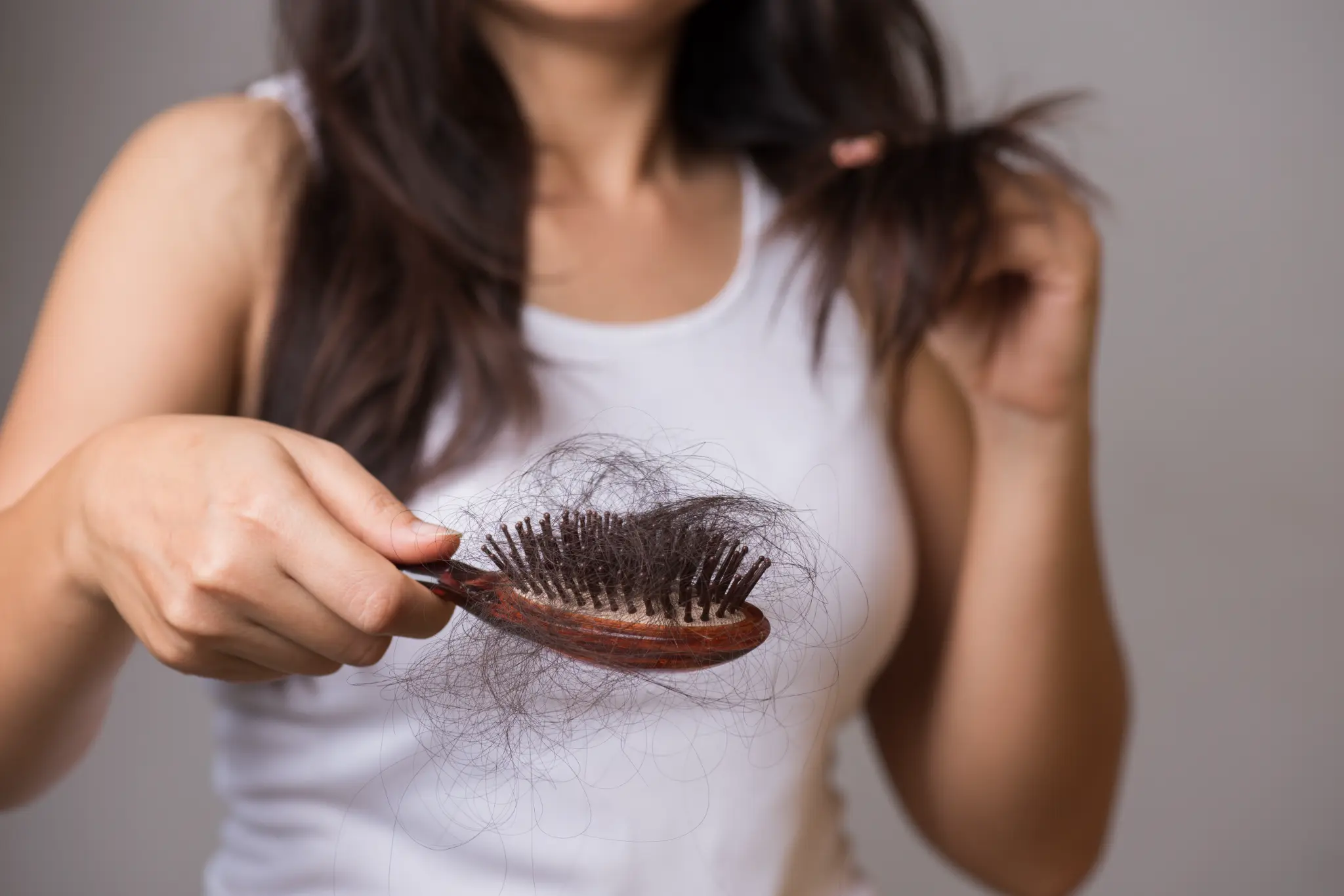 Woman concerned about hair loss with brush